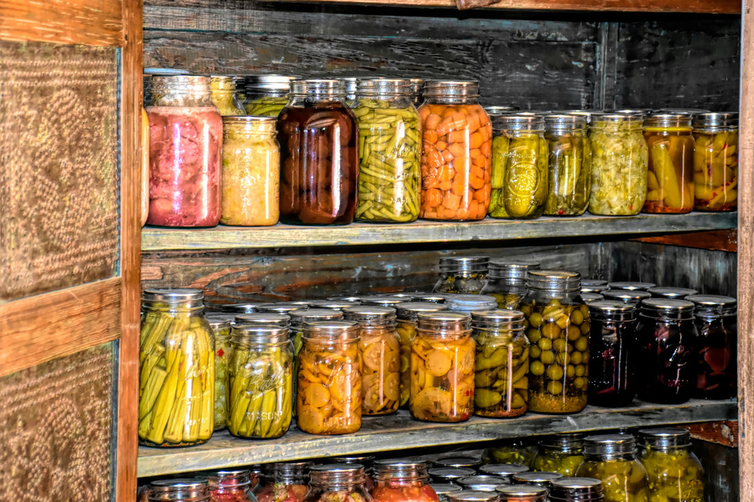 A collection of jars with preserved produce filling a cupboard